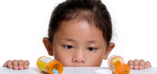 Bambina che guarda flaconi con medicinali